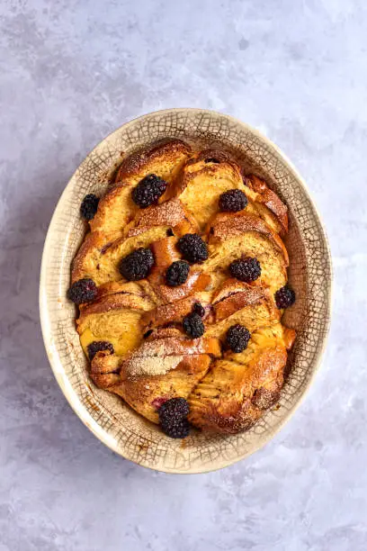 Traditional bread pudding in oval stoneware baking dish overhead view
