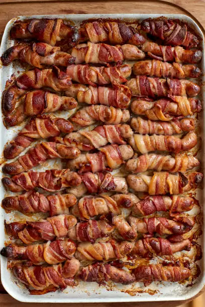 Overhead view of a tray of cooked pigs in blanket