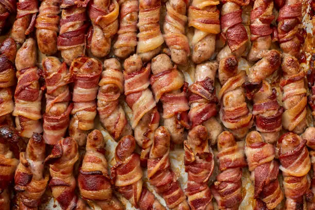 Cooked pigs in blanket or bacon wrapped sausages for backgrounds