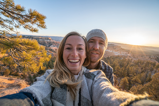 Couple take selfie at Bryce Canyon in Utah, United States, people travel explore nature. Young people hiking and travels
