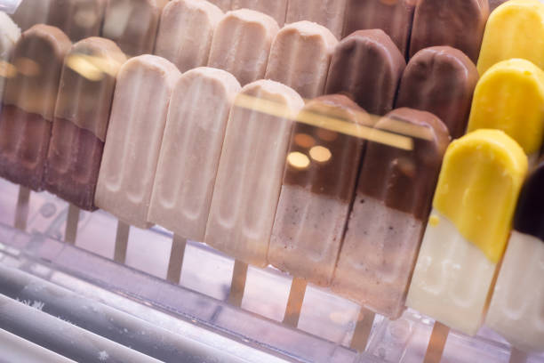 Showcase with different kind of tasty ice cream, popsicles with chocolate on sticks
