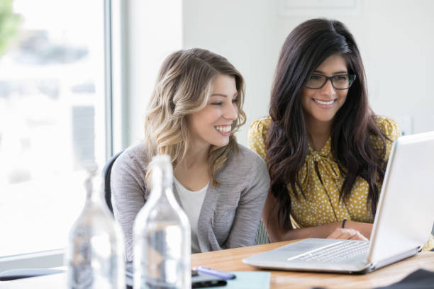 istock Young professional businesswomen using laptop while working in office 1146825652