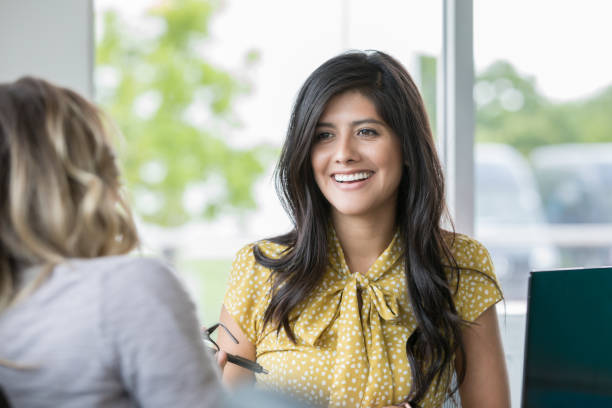 istock Beautiful Hispanic businesswoman interviews someone or discusses work assignment in office 1146826421