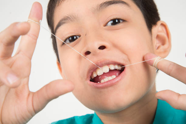 istock Little boy using dental floss to clean tooth 1146826491