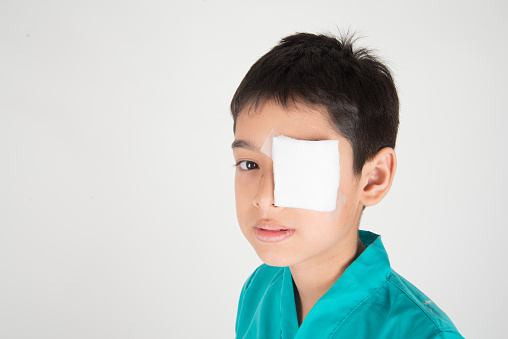 Little boy has eyes pain use bandage to cover