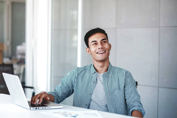 istock Happy Young Businessman Working on Computer Laptop in Office. Smiling and looking away 1146826581