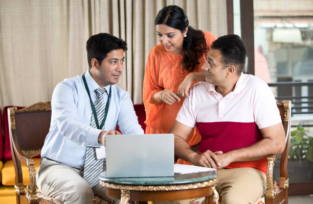 consulente finanziario con la famiglia indiana - consultant explaining computer home interior foto e immagini stock
