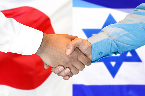 Business handshake on the background of two flags. Men handshake on the background of the Japan and Israel flag. Support concept