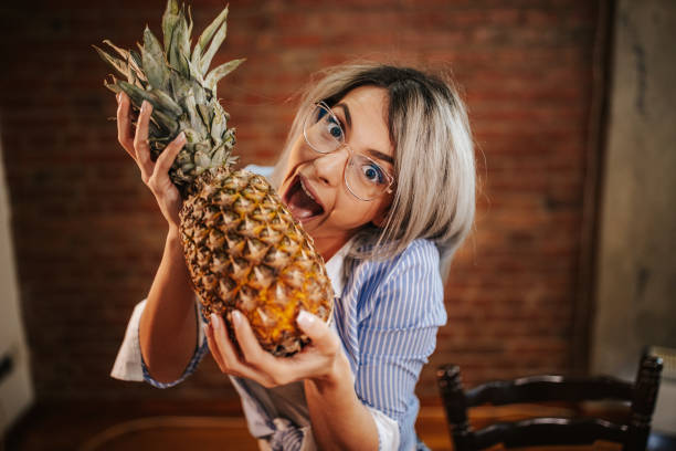 istock Happy young woman holding a pineapple 1146835301