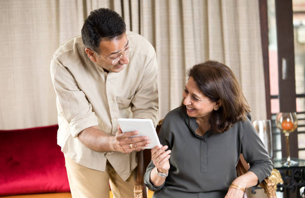 istock Man with senior mother using digital tablet at home 1146835320
