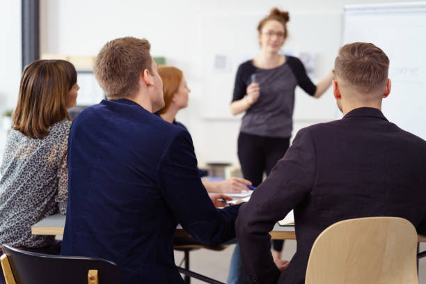 istock Rear view from backs of employees at staff meeting 1146839671