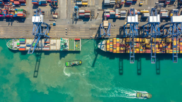 istock Container ship in export and import business logistics and transportation. Cargo and container box shipping to harbor by crane. Water transport International. Aerial view and top view. 1146841475