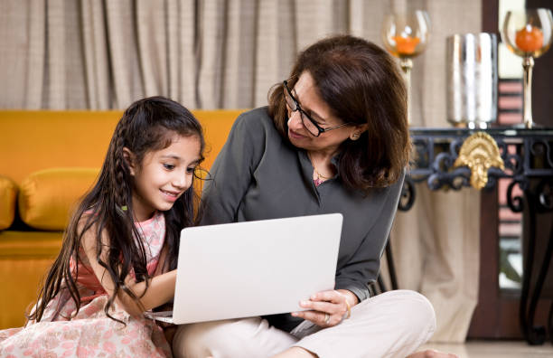 istock Grandmother with granddaughter using laptop at home 1146841507