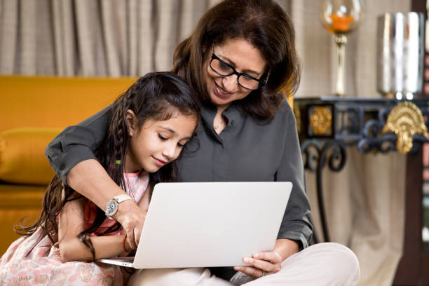 istock Grandmother with granddaughter using laptop at home 1146841537