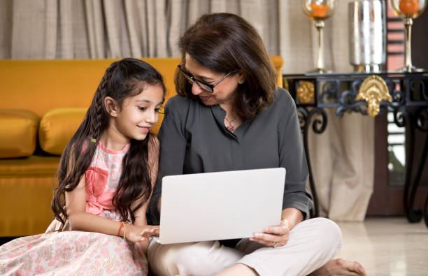 istock Grandmother with granddaughter using laptop at home 1146841580