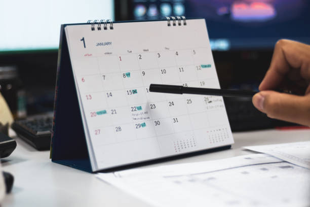 istock Hand with pen point on calendar page 1146846773