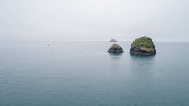 rocas en el agua en el día tranquilo de niebla. océano pacífico cerca de trinidad, costa oeste, california. - humboldt county california coastline island fotografías e imágenes de stock