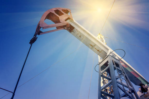 istock Oil field with pump jack, profiled on blue sky with white clouds, on a sunny day in spring. 1146858311