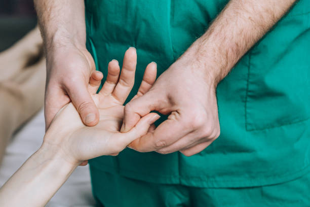 Wrist massage. Wrist massage. A male massage therapist puts pressure on a sensitive point on a woman's hand. thumb stock pictures, royalty-free photos & images