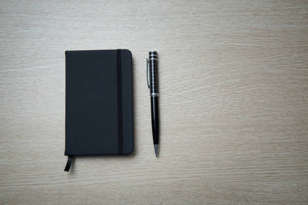 istock Black notebook and pen on the table on left top view. 1146858688