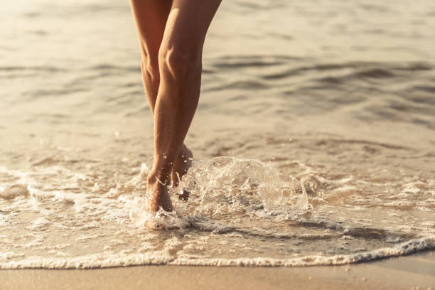 istock Female legs walking in water 1146859864