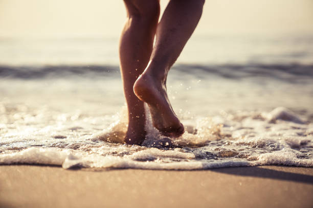 istock Female legs walking in water 1146859866