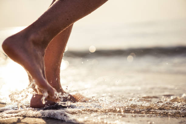 istock Female legs walking in water 1146859869