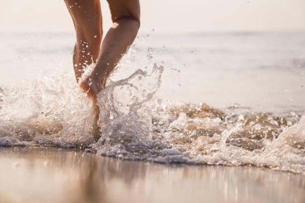 istock Female legs walking in water 1146859873