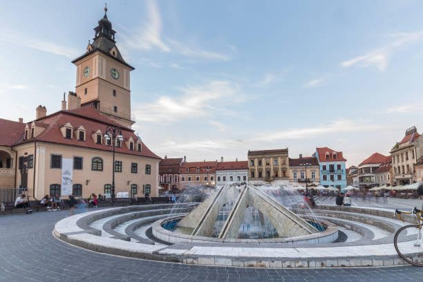 On the square in the old town there is a working fountain and a lot of beautiful and restored architecture in the city of Brasov in Romania
