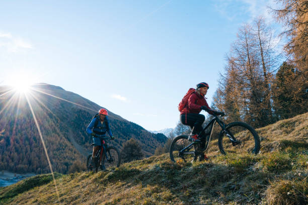 istock Mountain bikers ride up grassy slope 1146866214