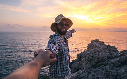 Happy tourist taking selfie standing on rocks