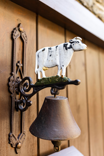 Door bell with a decorative cow in a village