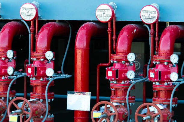 tubazioni principali dell'acqua di alimentazione nel sistema di estinzione incendi. impianto di irrigazione antincendio con tubi rossi. soppressione incendi. valvola manuale del sistema estintore. - exploitation foto e immagini stock