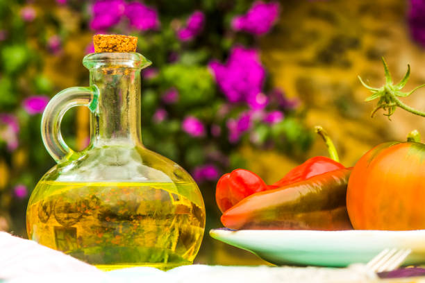 Virgin olive oil in a rustic bottle, tomatoes, peppers on a sunny day in the countryside