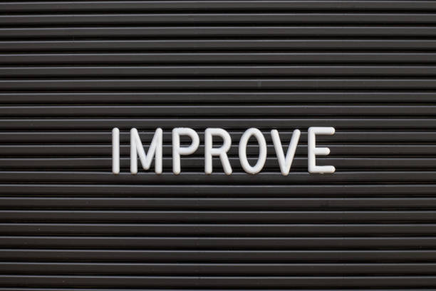 istock Black color felt letter board with white alphabet in word improve background 1146889622