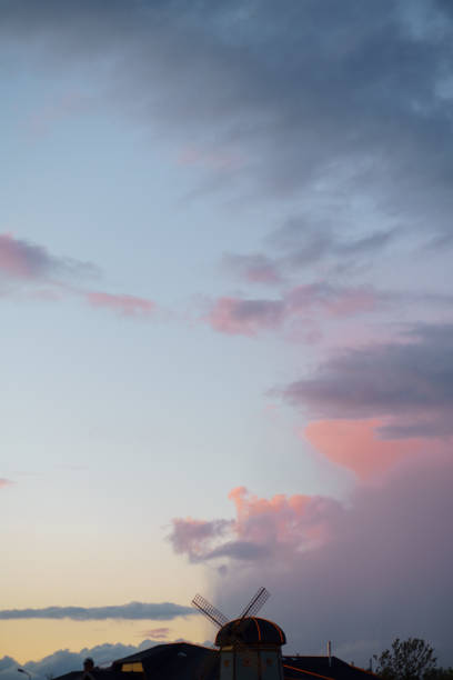 Pink vivid sunset with a mill in the background - Rainy clouds taking over in this beautiful landscape scenery of our nature Pink vivid sunset with a mill in the background - Rainy clouds taking over in this beautiful landscape scenery of our nature - Colorful sunrise - Video footage from this set is available too. dorchester on thames stock pictures, royalty-free photos & images