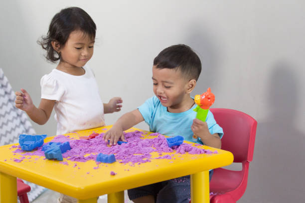 istock two little kids play sand at home 1146894095