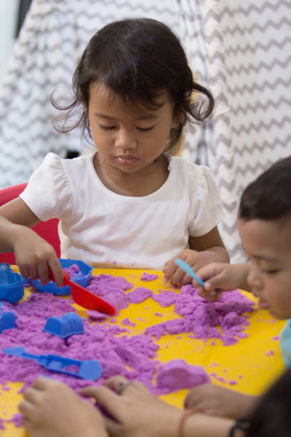 istock two little kids play sand at home 1146894113