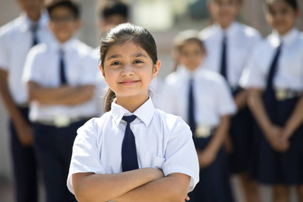 Portrait of confident girl with arms crossed in school uniform