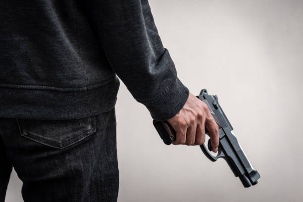 un uomo che teneva una pistola in mano, la nave pronta a sparare all'uomo ci ha puntato una pistola contro. un uomo armato di pistola è stato derubato. - gun gunman handgun men foto e immagini stock