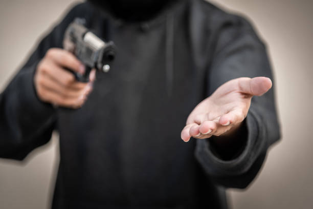 pistola y dinero en manos. robo de un banco, hombre llevando un arma para robar el dinero. para amenazar con el pistolero - gun currency crime mafia fotografías e imágenes de stock