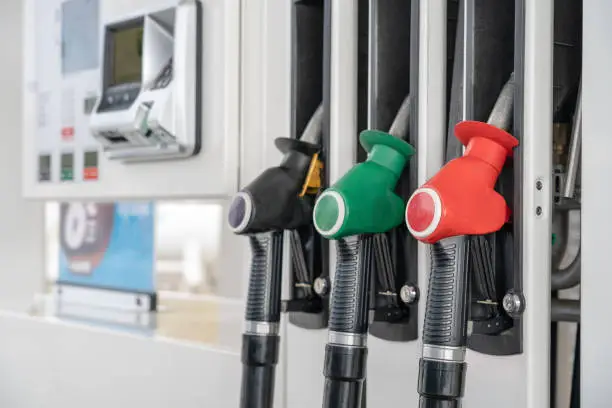 Photo of Red green black color fuel gasoline dispenser background. Close-up fuel nozzles on petrol and diesel fuel.