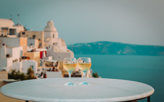 romantic vacation in Greece -two wine glasses in Santorini with sea view