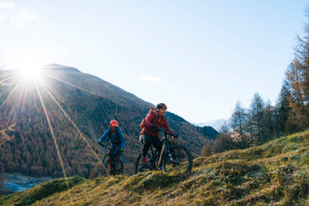 istock Mountain bikers ride up grassy slope 1146909457