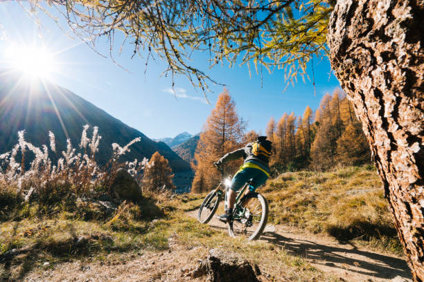 mountain biker chevauche la pente herbeuse - moving up flash photos et images de collection