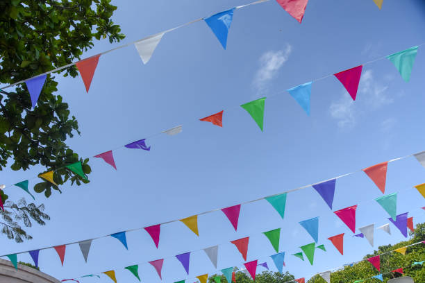 istock low angle view of colorful flags against blue sky 1146910853