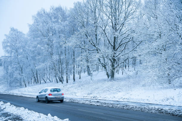 istock A car driving on a road in a cold, snowy landscape. 1146919934
