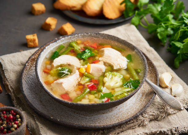 istock Homemade chicken soup with vegetables, broccoli on dark brown background, side view. 1146919994