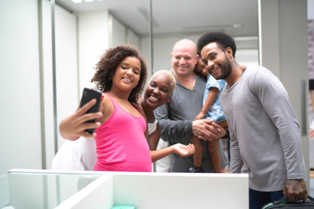 familia tomando una autofoto dentro del armario - two parent family technology mobility men fotografías e imágenes de stock
