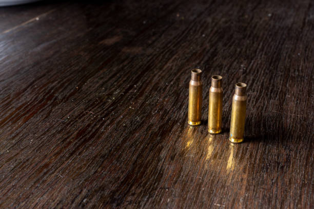 istock Empty bullet casings on a dark, wooden table. 1146921067